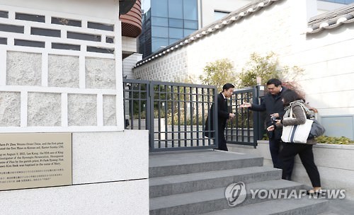 1月19日上午，在首尔市嘉会洞天主教堂，参加Rain和金泰希婚礼的一位宾客走进教堂。（韩联社）